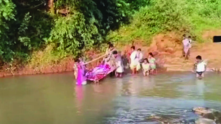 ഒഡീഷയിലെ ഖമാന്‍പാഡയില്‍ രോഗിയെ ആശുപത്രിയിലെത്തിക്കാന്‍ കട്ടിലില്‍ ചുമന്ന് നദി കടത്തുന്നു