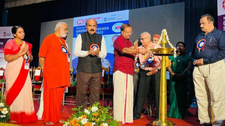 Union Minister V. Muraleedharan inaugurates the "Garbha Samskara Suputreeyam” national seminar. Also seen are L/R: Dr. Jayalakshmi Ammal, Swami Sankaramaruthananda Puri,  Dr. Mohan Kunnummel, Dr. T.T. Krishnakumar, Dr. Surendra Choudhary, Dr. Suresh Jakotia, Dr. Harita and Dr. Ravikumar Kallyanasseril.